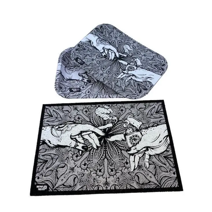 Two items, a rectangular mat and a matching rolling tray, both featuring a black and white intricate design of hands passing a lit joint and a lighter, set against a white background.