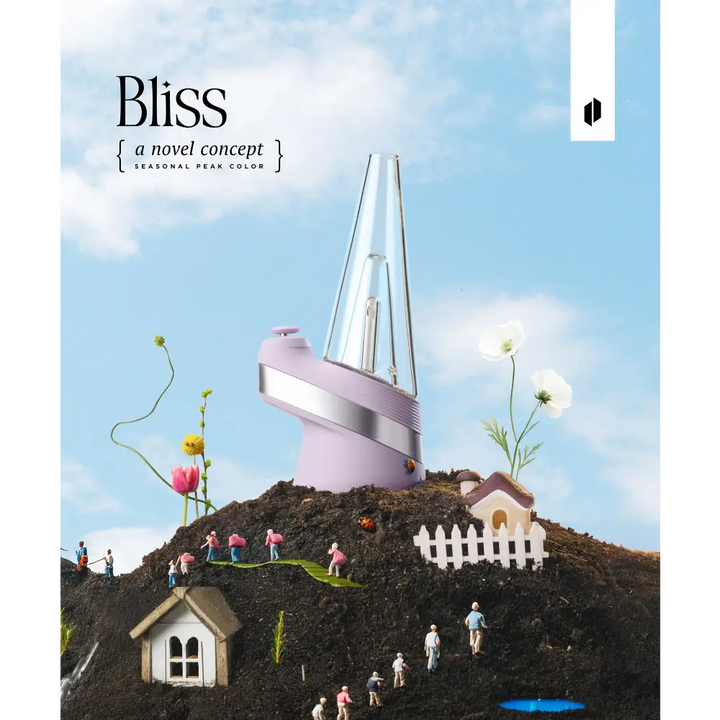 A lavender Puffco Peak vaporizer sits atop a miniature dirt hill with tiny houses, people, and flowers under a blue sky, showcasing the 'Bliss' seasonal color.