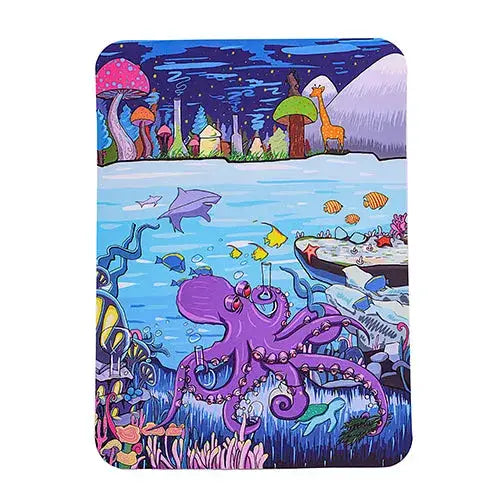 A silicone dab mat featuring a vibrant cartoon illustration of an underwater scene with a purple octopus, fish, and a shark, beneath a fantastical land with colorful mushrooms and a giraffe, all against a white background.