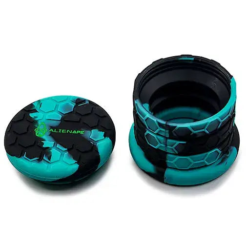 Two-part collapsible silicone jar in teal and black hexagonal pattern, with the lid featuring an 'ALIENAPE' logo placed next to the open, expanded body of the jar.
