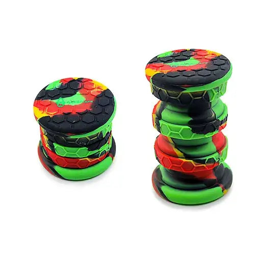 Two collapsible silicone storage jars, one collapsed and one extended, featuring a Rasta-colored swirl pattern with a hexagonal texture, against a white background.