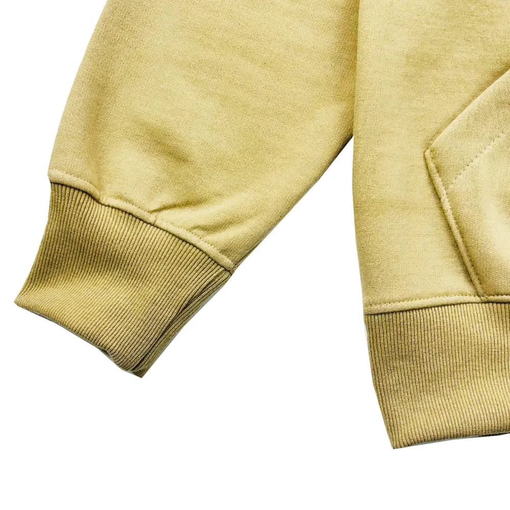 Close-up detail shot of a light brown hoodie's ribbed sleeve cuff and bottom hem, showcasing the fabric texture.