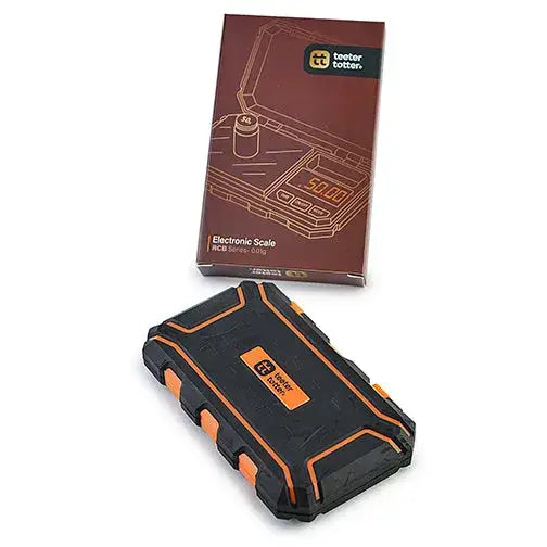 Black and orange electronic scale with a rugged design, displayed next to its brown retail packaging box.