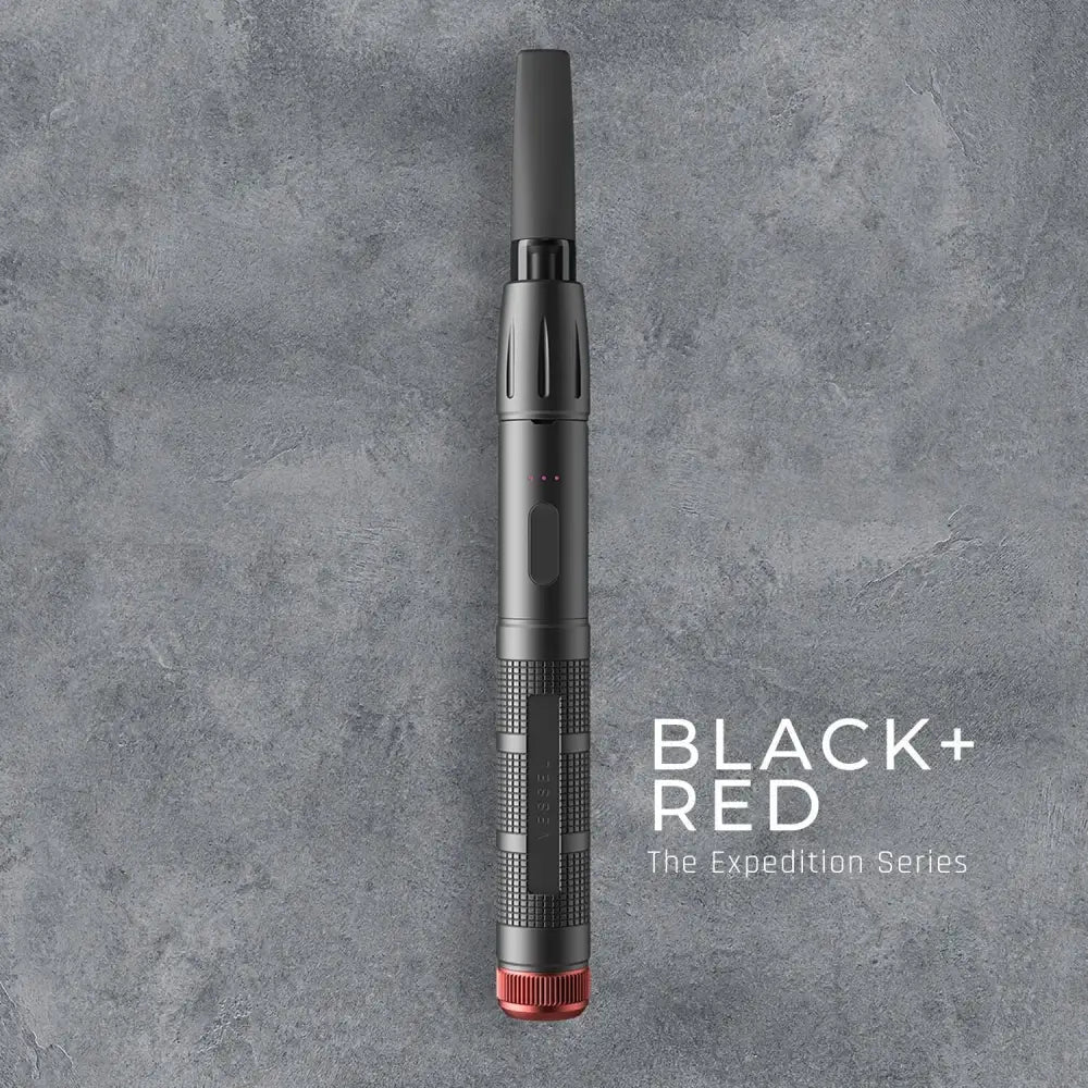Top-down view of a black pen-style vaporizer with a red base, featuring textured grip sections and a small indicator light, against a dark gray textured background with 'BLACK + RED The Expedition Series' text.