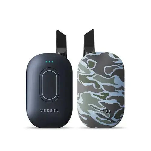 Two compact, oval-shaped vaporizers are shown side-by-side, one in dark grey and the other with a green and blue camouflage pattern.