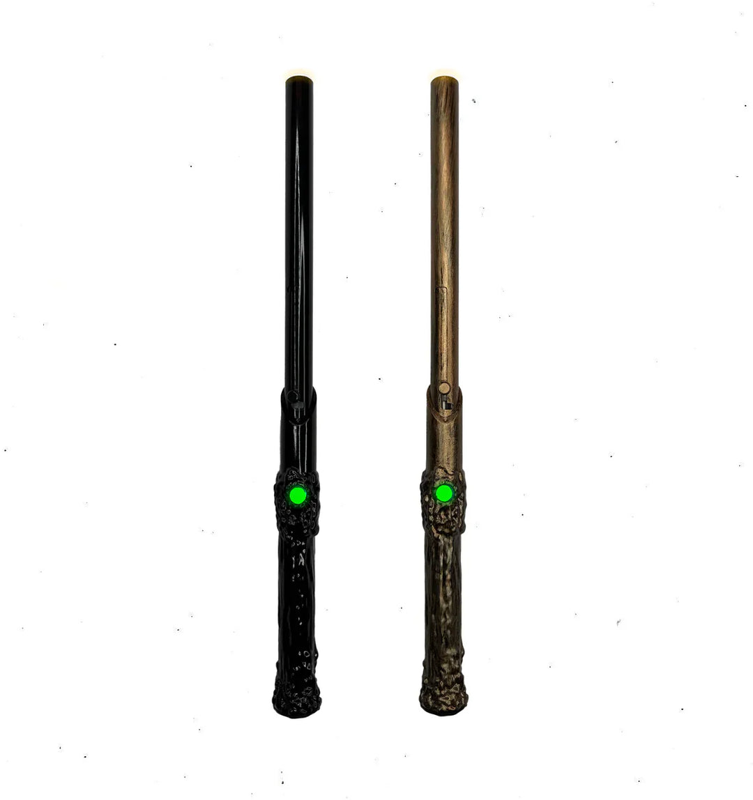 Two slender, wand-like devices, one black and one bronze, each with a textured handle and a glowing green light near the base of the shaft.