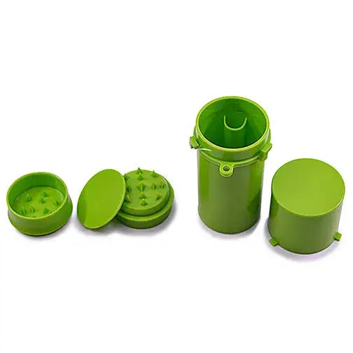 A disassembled bright green herb grinder with spiked teeth and a matching green cylindrical storage container with its lid off, all arranged on a white background.